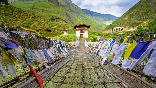 walking suspension bridge with a lot of colorful prayer flags in Bhutan