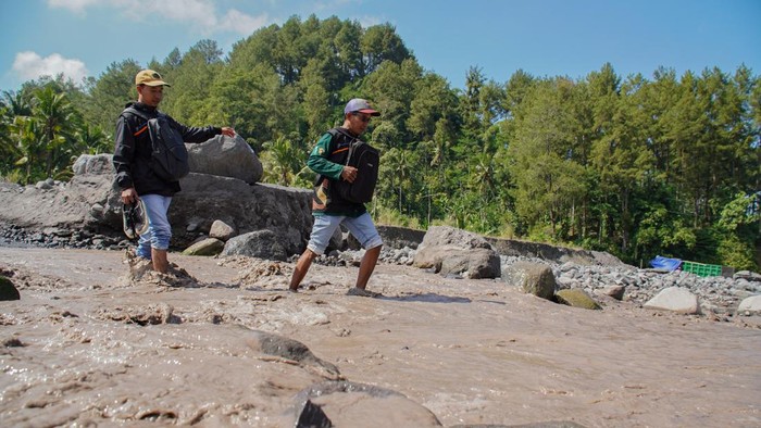Sensus Ekonomi Terus Berjalan dari Kota hingga Pelosok RI Dua petugas sensus melintasi aliran lahar hujan Gunung Semeru saat melaksanakan Sensus Ekonomi 2026 di Desa Sumberlangsep, Kecamatan Candipuro, Lumajang, Jawa Timur, Kamis (25/6/2026). Meski menempuh medan dengan akses jalan terbatas dan minim jaringan internet, petugas tetap melakukan pendataan secara jeli dan menjunjung etika statistik dalam penyelenggaraan Sensus Ekonomi 2026 untuk menyediakan info dasar aktivitas upaya sebagai referensi penyusunan kebijakan pembangunan ekonomi. ANTARA FOTO/Irfan Sumanjaya/tom.