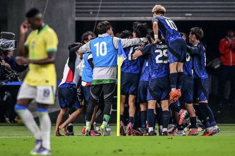Japans players celebrate after scoring a goal during the international football friendly match between Japan and Brazil at the Tokyo stadium in Chofu, Tokyo prefecture on October 14, 2025. (Photo by Yuichi YAMAZAKI / AFP)