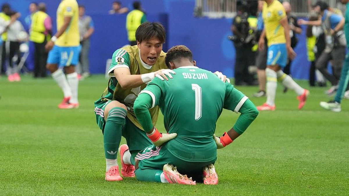Zion Suzuki ditenangkan oleh rekannya. (Foto: Getty Images/Masashi Hara)