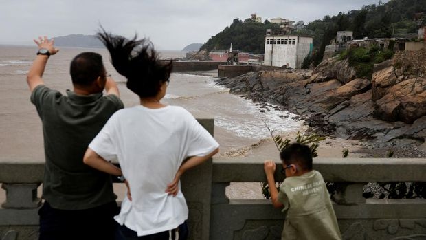 Warga memandang ke arah laut setelah Topan Bavi melanda wilayah tersebut di desa pesisir Diaocaocun, Taizhou, provinsi Zhejiang, China, 12 Juli 2026. (REUTERS/Go Nakamura)