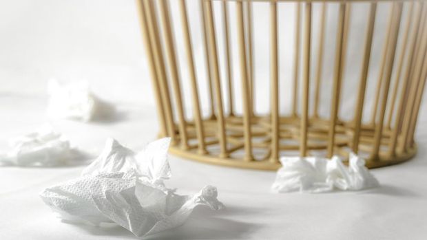 ilustrasi tisu berserakan di lantai Four white used tissue paper on the white floor and trash basket on background ,selective focus on foreground.Keep clean concept.