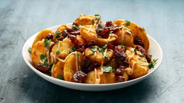 Makanan Spanyol Patatas bravas Patatas bravas with chorizo and sauce. Spanish traditional food.
