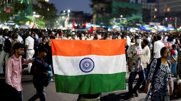 Gelombang Demo Besar Goyang India A man holds an Indian national flag as he participates in a demonstration in solidarity with Cockroach Janta Party (CJP) protests held at Jantar Mantar in New Delhi, which demand the resignation of India's Education Minister Dharmendra Pradhan over exam paper leaks, in Kolkata, India, July 24, 2026. REUTERS/Sahiba Chawdhary TPX IMAGES OF THE DAY