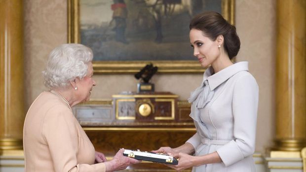 Angelina Jolie mengenakan Ralph & Russo Couture saat bertemu Ratu Elizabeth II untuk menerima gelar kehormatan Dame atas upayanya memerangi kekerasan seksual. Desember 2014