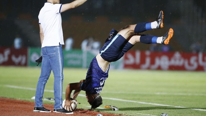 TEHRAN, IRAN - JULY 31: (BILD ZEITUNG OUT) head coach Yahya Golmohammadi of Persepolis looks on, Nader Mohammadi of Peykan does a somersault throw-in during the Persian Gulf Pro League Match between Paykan and Persepolis at Shahr-e Qods Stadium on Ju