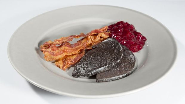 Swedish Blood Pudding with Bacon and Lingonberry Jam on plate with white background.