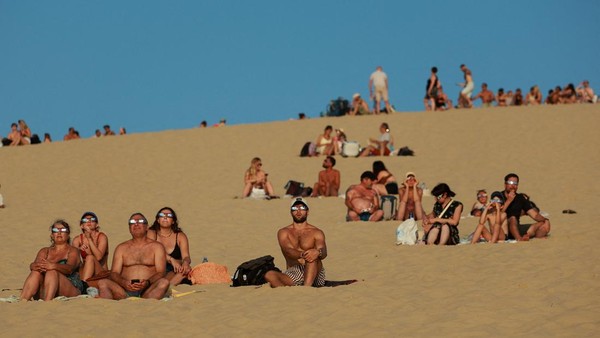 Momen spektakuler gerhana matahari sebagian menarik perhatian warga di Bukit Pasir Pilat, La Teste-de-Buch dekat Arcachon, Prancis, pada 12 Agustus 2026. Fenomena langit tersebut menjadi tontonan istimewa bagi masyarakat yang datang untuk menyaksikannya. REUTERS/Stephanie Lecocq