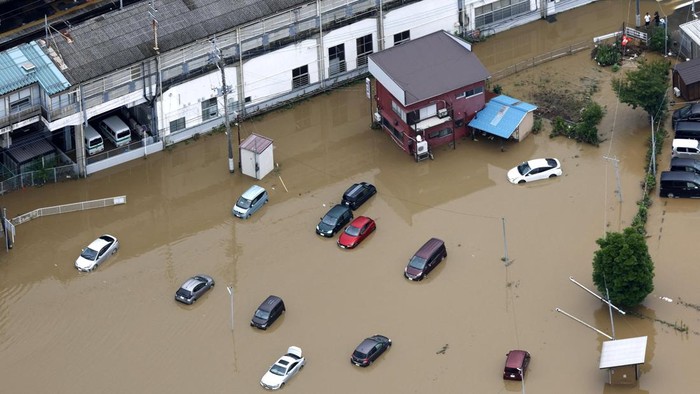 People walk on a flooded road after torrential rain in Chiba, Chiba Prefecture, Japan, August 14 2026. Kyodo/via REUTERS ATTENTION EDITORS - THIS IMAGE WAS PROVIDED BY A THIRD PARTY. EDITORIAL USE ONLY. MANDATORY CREDIT. JAPAN OUT. NO COMMERCIAL OR E
