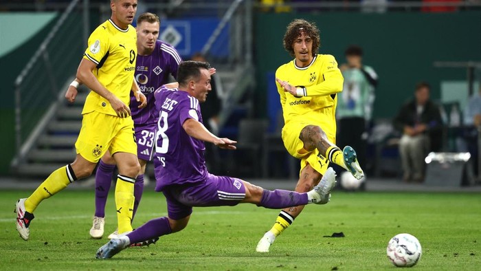 01 September 2026, Hamburg: Soccer, Men: DFB Cup, HEBC vs. Borussia Dortmund, First Round, Volksparkstadion; Fbio Silva (R, Borussia Dortmund) scores the goal to make it 05 against Jorma Eggers (M, HEBC). Photo: Christian Charisius/dpa - IMPORTANT NO