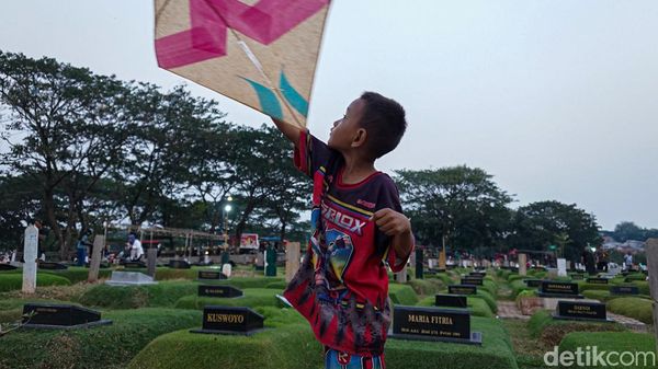 Di Sela Makam, Anak-anak Tetap Riang Bermain Layangan di TPU Tanah Kusir