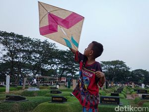 Di Sela Makam, Anak-anak Tetap Riang Bermain Layangan di TPU Tanah Kusir