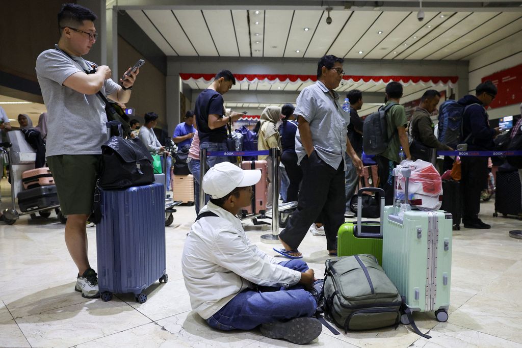 Penumpang yang terdampar menunggu di area check-in saat Bandara Internasional Soekarno Hatta menutup operasinya akibat letusan gunung berapi Gunung Anak Krakatau, di Tangerang, dekat Jakarta, Indonesia, 6 September 2026. (REUTERS/Ajeng Dinar Ulfiana)