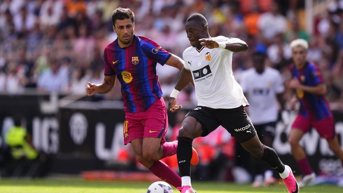 Aliou Dieng defensive midfield of Valencia and Mali and Rodri Hernandez defensive midfield of Barcelona and Spain compete for the ball during the LaLiga EA Sports 2026/27 match between Valencia CF and FC Barcelona at Estadi de Mestalla on September 6