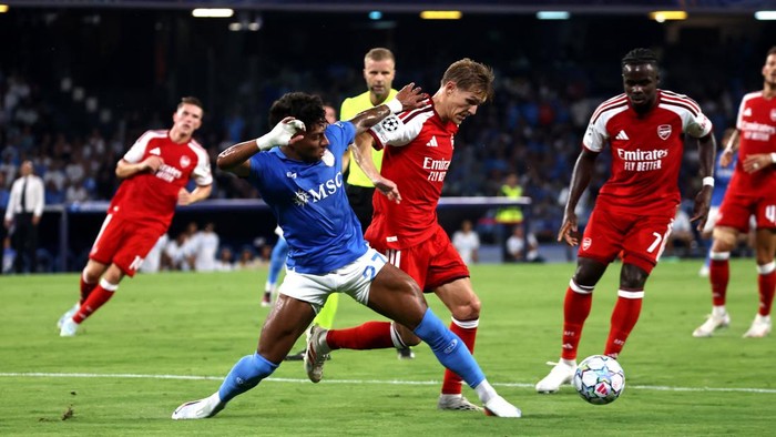 NAPLES, ITALY - SEPTEMBER 09: Alisson Santos of SSC Napoli competes for the ball with Martin Odegaard of Arsenal FC during the UEFA Champions League 2026/27 League Phase MD1 match between SSC Napoli and Arsenal FC at Stadio Diego Armando Maradona on 