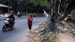 Semrawut! Kabel Fiber Optik Bergelantungan di Jalan Raya Cirendeu