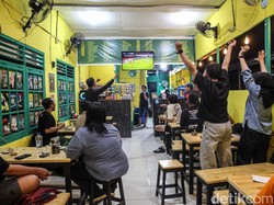 Suasana warung seketika pecah. Para penonton bersorak dan menunjukkan ekspresi gembira setelah Timnas Indonesia berhasil mencetak gol dalam pertandingan final tersebut.