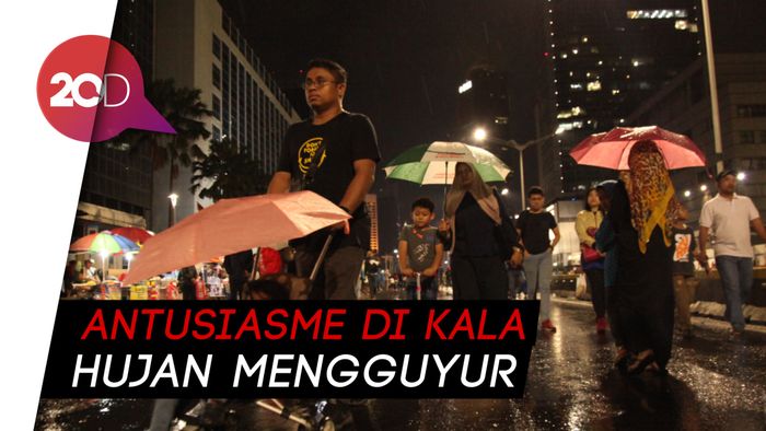 Di Bawah Deras Hujan, Warga Nikmati Malam Tahun Baru di Monas