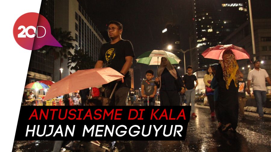 Di Bawah Deras Hujan, Warga Nikmati Malam Tahun Baru di Monas
