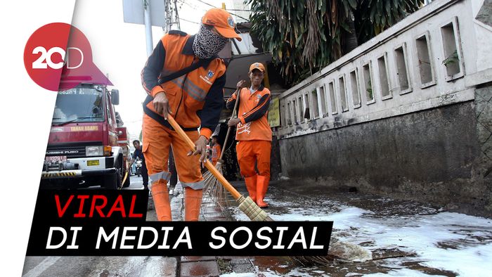 Aksi Petugas PPSU Bersihkan Got saat Jakarta Banjir
