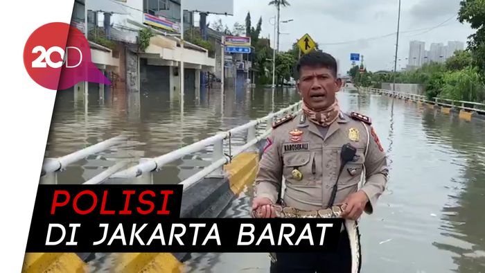 Waduh! Polisi Ini Jelaskan Kondisi Banjir Sambil Pegang Ular