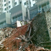 Alat Berat Evakuasi Puing Tembok Apartemen Essence