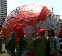 Buruh Gelindingkan Bola Raksasa