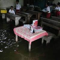 Siswa SD Kerjakan UAS di Tengah Banjir 