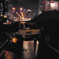 Petugas Evakuasi Mobil-mobil di Kolong Truk Kontainer