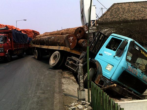 Truk Bermuatan Kayu Terperosok
