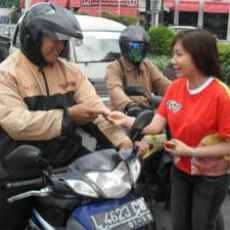 Boneka Hijau Bagi-bagi Biskuit di Traffic Light