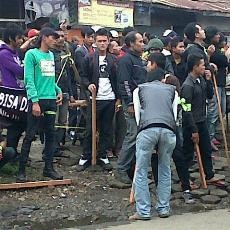 Seratusan Pria Berbekal Kayu Pasang Badan di Hadapan Polisi
