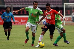 Pemain Persija Pedro Javier (tengah), melewati hadangan dua pemain lawan.