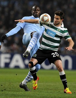 Mario Balotelli berebut bola dengan Bruno Pereirinha. Dalam pertandingan tersebut, Balotelli menyumbangkan satu gol untuk City melalui titik putih di menit ke-75. Reuters/Nigel Roddis