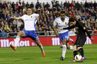 Lionel Messi meliuk-liuk untuk melewati pemain lawan dalam pertandingan yang digelar di Estadio La Romareda, Minggu (8/4/2012) dinihari WIB. Reuters/Albert Gea.