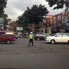 Saat Mengatur Lalu Lintas, Polisi Malah Asik SMS-an
