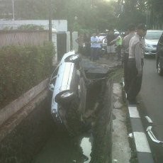 Sopir Mengantuk, Mercy Putih Terguling Masuk Selokan di Jl Dharmawangsa