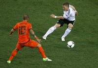 Bastian Schweinsteiger menggocek bola untuk melewati Wesley Sneijder. Reuters/Yves Herman