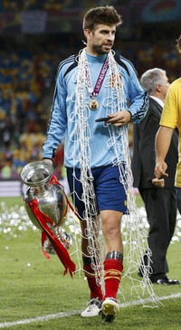 Seperti biasa, usai menggondol juara, Gerard Pique selalu mengambil jaring gawang. REUTERS/Alessandro Bianchi.