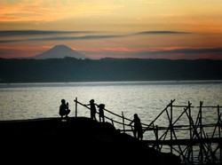 Anak-anak bermain di pinggir pantai