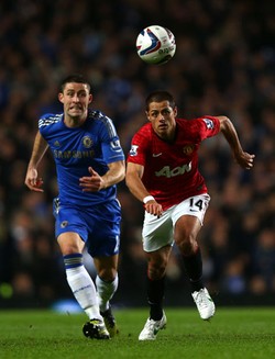 Gary Cahill berebut bola dengan Javier Hernandez. Dalam pertandingan ini, Cahill berhasil membobol gawang MU di menit ke-52. Clive Rose/Getty Images.