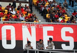 Tiga personel aparat kepolisian tengah berjaga-jaga, saat laga ujicoba internasional Indonesia melawan Timor Leste.