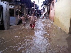 Byur! Banjir di Kampung Melayu Jadi Kolam Renang Dadakan Para Bocah