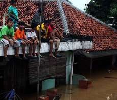 Santai! Menikmati Pemandangan Banjir Cililitan dari Atap Rumah