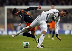 Cristiano Ronaldo dikawal ketat pemain Valencia Pablo Piatti. REUTERS/Susana Vera.