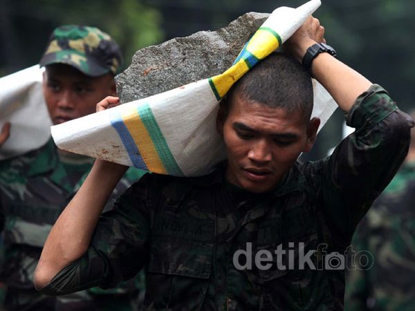 Prajurit TNI Panggul Batu untuk Bendung Banjir