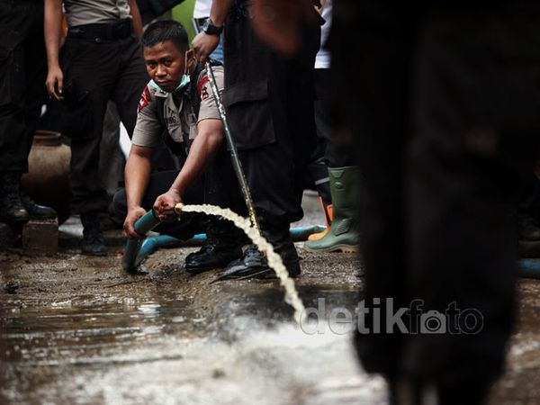 Polisi Bersih-bersih Sisa Banjir di Kampung Pulo