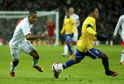     Theo Walcott berusaha melewati Adriano. Reuters/Eddie Keogh.