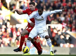 Steven Gerrard berebut bola dengan Kemy Agustien dalam pertandingan yang dihelat di Anfield, Minggu (17/2/2013) malam WIB. Reuters/Darren Staples.
