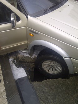 Hujan Deras, Mobil Ford Everest Terperosok di Lubang Jalan Depan KPK